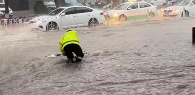 暴雨袭城交警冒雨护交通 河北承德短时强降水致道路成河